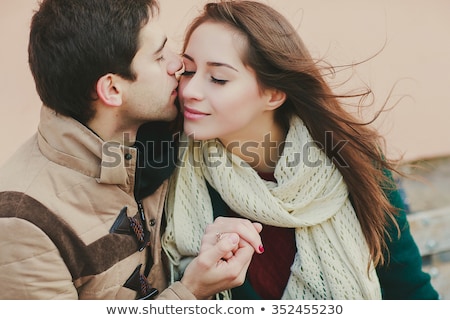 Stok fotoğraf: Romantic Woman Kissing On The Cheek Of Man Holding A Heart Shape