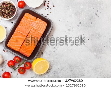 Plastic Container With Fresh Salmon Slice With Oil Tomatoes And Lemon On Stone Kitchen Background S Foto stock © DenisMArt