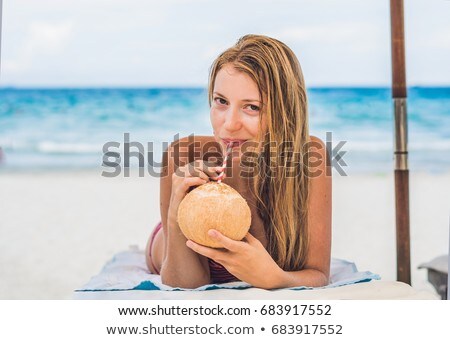 Stock fotó: Young Woman Drinking Coconut Milk On Chaise Longue On Beach