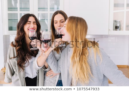 ストックフォト: ャンパンを飲み、笑顔のリビングルームで3人の女性