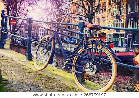 Foto stock: Old Bicycle Next To Canal Of Amsterdam