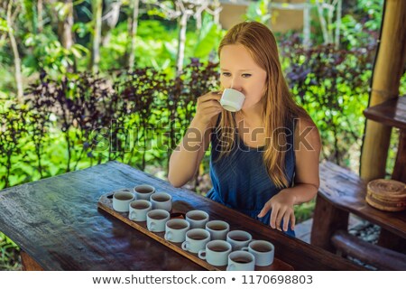 Stockfoto: A Young Woman Is Tasting Different Kinds Of Coffee And Tea Including Coffee Luwak