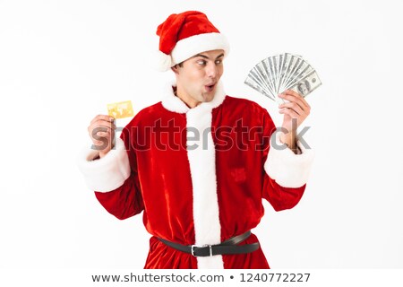 Zdjęcia stock: Image Of Surprised Man 30s In Santa Claus Costume Holding Dollar