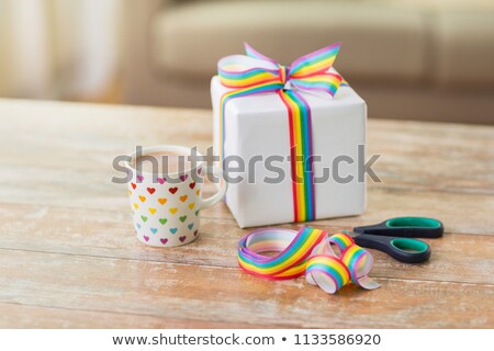 Foto stock: Present With Gay Awareness Ribbon On Table At Home