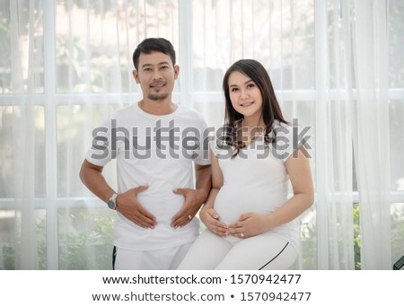 [[stock_photo]]: Pregnant Woman With Her Man Listening To The Belly