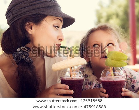 ストックフォト: Friendly Kid Girl And Fun Emotional Mother Drinking Berries Smoothie Juice Together In Street Cafe A