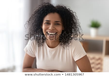 Stock photo: Overjoyed Relaxed Curly Young African American Woman Enjoys Spare Time At Home Lies In Bed With Mod