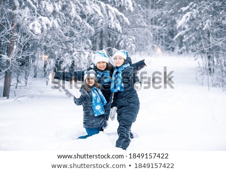 Stock photo: Young Family In A Winter Forest With Sparklers