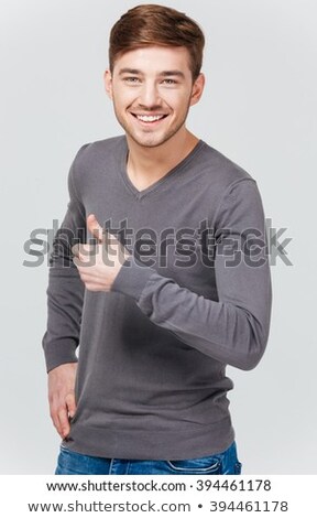 ストックフォト: Happy Handsome Young Man In Grey Pullover Showing Thumbs Up