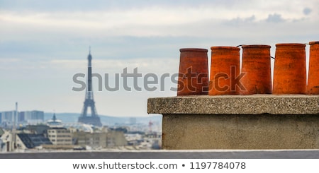 Stock fotó: The Roofs Of Paris And Its Chimneys Under A Clouds Sky