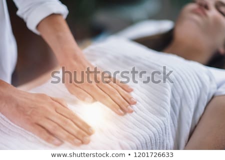 Zdjęcia stock: Therapist Performing Reiki On Young Woman