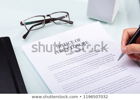 Stock foto: Woman Holding Pen Over Notice Of Foreclosure Document