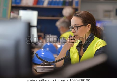 Stok fotoğraf: Young Woman Controlling Process In The Factory With Male Worker