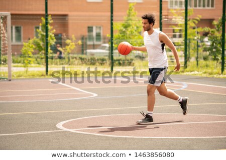 Foto stock: Young Basketballer In Sportswear With Ball Running Down Playground