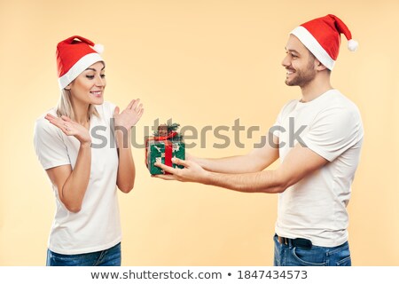 Foto stock: Young Man Giving Surprise Gift Box To Woman Isolated On Beige Background