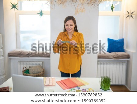 Foto stock: Picture Of Good Looking Woman In Light Clothes Standing With Coffe And Recordings In Hands