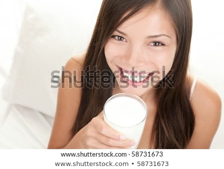 Pretty Girl Drinking Milk On The Bed Stockfoto © Ariwasabi