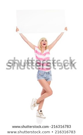 ストックフォト: Image Of Excited Blonde Woman Holding Placard Above Head And Smiling