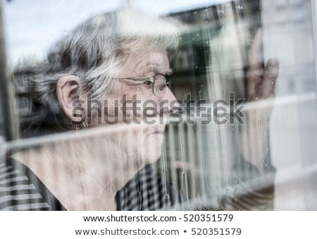 Senior Woman Looking Out Through A Window Like Depress ストックフォト © Lopolo