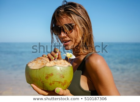 Stockfoto: Attractive Young Woman Drinking Coconut Water On The Beach
