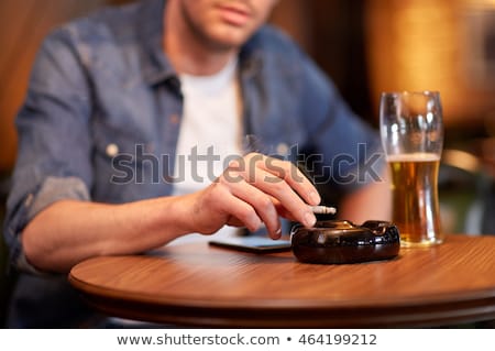 Stock photo: Man Drinking Beer And Smoking Cigarette At Pub