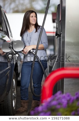 Stockfoto: Woman Fills Petrol Into Her Car