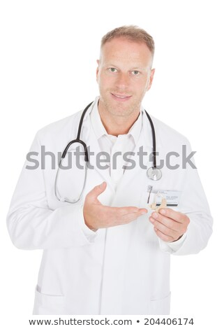 Stock fotó: Man Looking At Doctor Holding Hearing Aid