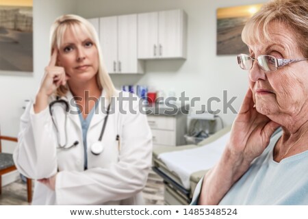 Stock fotó: Empathetic Doctor Standing Behind Troubled Senior Adult Woman In