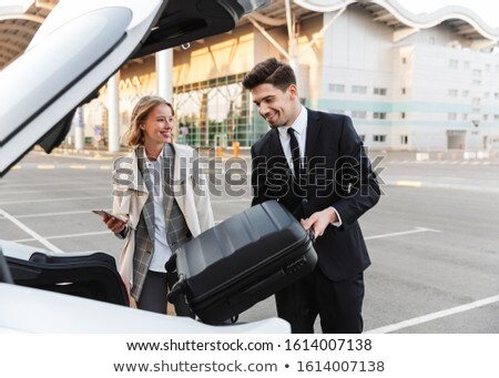 Stockfoto: Image Of Young Businesslike Man And Woman Putting Luggage In Car