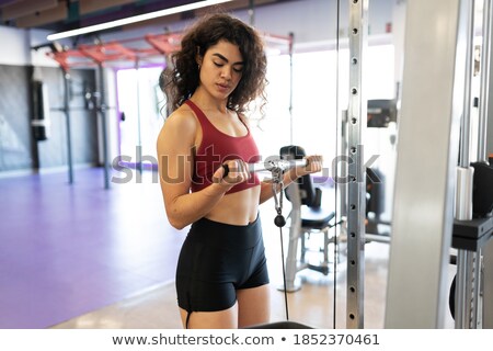 Stock photo: Fit Woman Using The Weights Machine For Her Arms