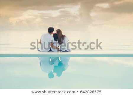 ストックフォト: Happy Family Hugging Near The Pool At Sunset