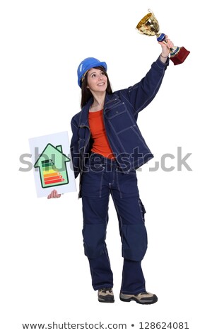 Stockfoto: A Female Construction Worker Holding A Trophy Cup