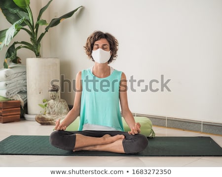 Foto stock: Woman Meditating In A Face Mask