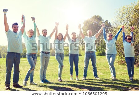 Foto stock: Group Of Happy Volunteers Holding Hands Outdoors