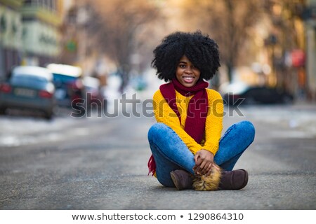 Cheerful Young Black Woman Is Sitting In The Middle Of The Stree Imagine de stoc © Stasia04