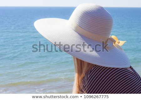 Foto stock: A Girl In A Summer Dress Hat And Sandals On The Terrace
