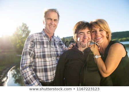 ストックフォト: Couple Outdoors With Disabled Person Daughter By Lake Having Good Time