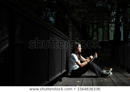 ストックフォト: Woman Sits Writing On Wooden Bridge