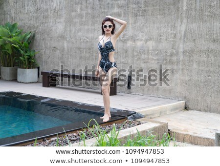 Stok fotoğraf: Young Woman Standing By The Swimming Pool