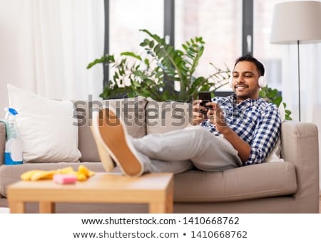 Foto stock: Indian Man In Headphones After Cleaning Home