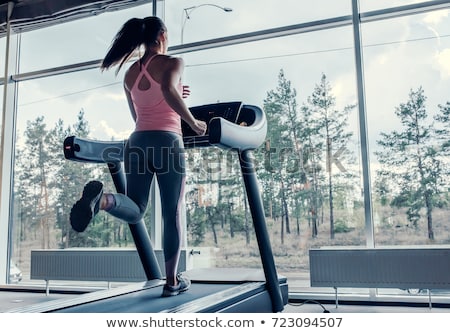 Zdjęcia stock: Beautiful Young Woman Running On A Treadmill In Gym