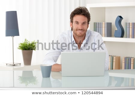 Stok fotoğraf: Portrait Of A Happy Young Man With Cup Of Coffee - Indoor