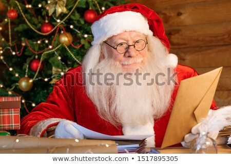 Stok fotoğraf: Santa In Eyeglasses And Costume Holding Envelope In Hand And Looking At Address