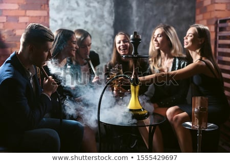 Stok fotoğraf: Beautiful Woman Smoking A Hookah And Drinking Tea In A Cafe
