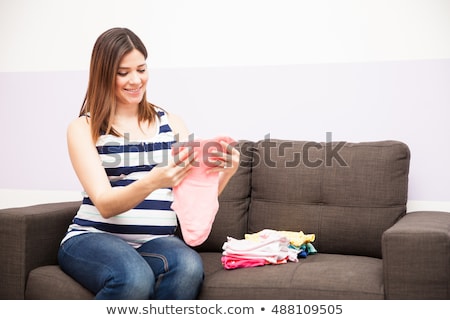 Stock photo: Mother Sorting Newborn Baby Clothing At Home