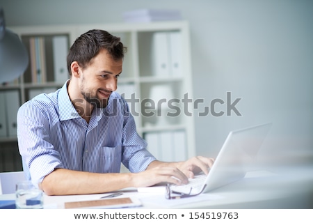 Portrait Of A Smiling Attractive Man Working On Laptop Stockfoto © Pressmaster