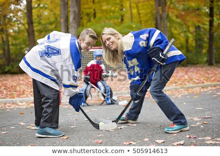 Portrait Of Happy Child Play Hockey Outside With Mother Foto d'archivio © Lopolo