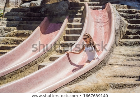 Foto stock: Woman On A Stone Water Slide In A Water Park Aqua Park Girl Slide Down On Water Slide