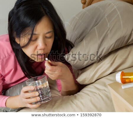 Stok fotoğraf: Mature Woman Taking Single Pill With Water