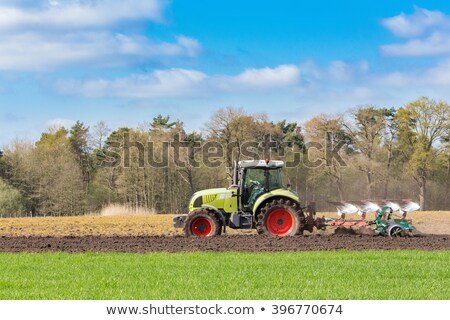 Foto stock: Farmer On Tractor Plowing Sandy Soil In Spring Season